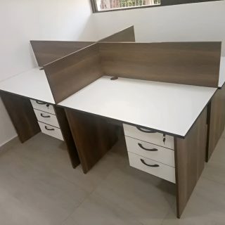 Modern 4-way office workstation with white desktops, privacy panels, and lockable storage drawers for corporate and co-working spaces.